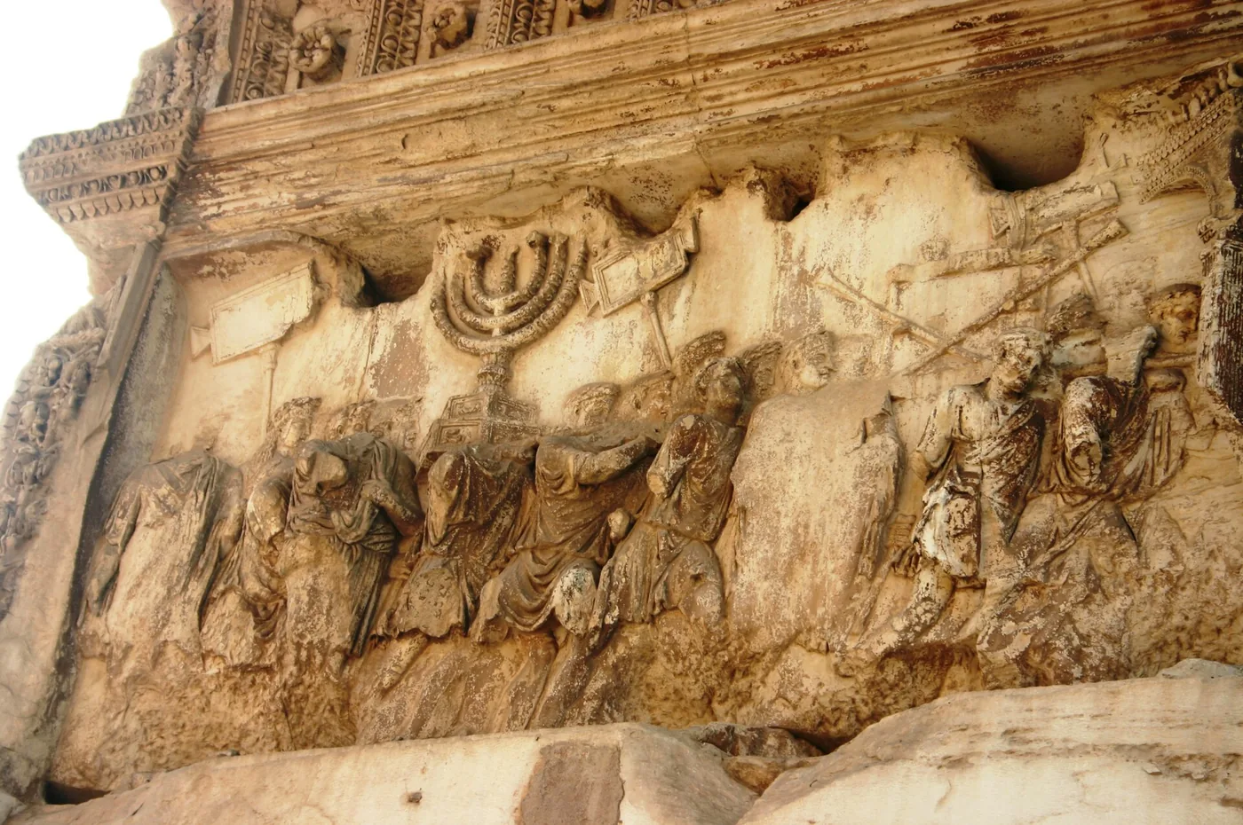 Weathered marble relief of Roman soldiers carrying a seven-branched lampstand in procession