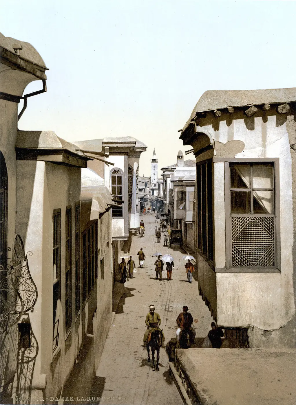 Colour photograph of about 1900 of a narrow Damascus street lined with houses and shops